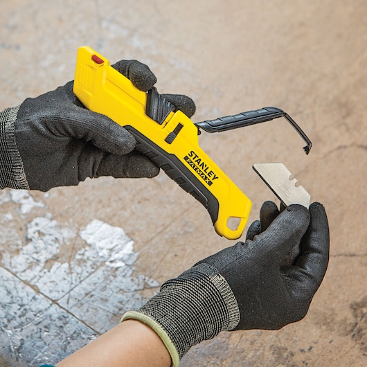 Fatmax auto retract tri slide safety knife head being fixed in.