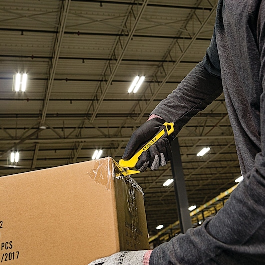 SINGLE SIDED BI MATERIAL PULL CUTTER being used for cutting cello tape on cardboard box.