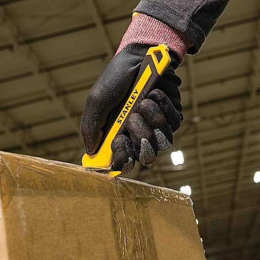 SINGLE SIDED BI MATERIAL PULL CUTTER cutting cello tape on box.