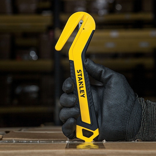 SINGLE SIDED ROUND TIP BI MATERIAL PULL CUTTER being used for opening box.