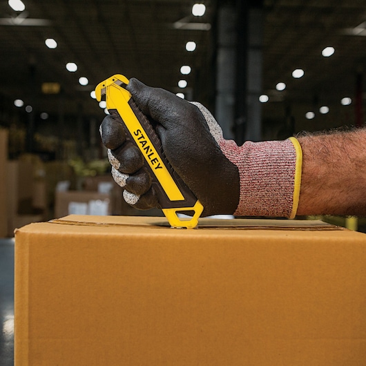 DOUBLE SIDED BI MATERIAL PULL CUTTER being used for opening package.