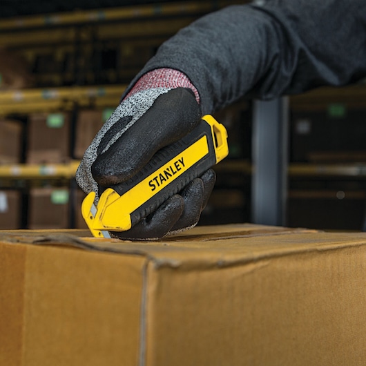 DOUBLE SIDED BI MATERIAL PULL CUTTER being used for opening box.