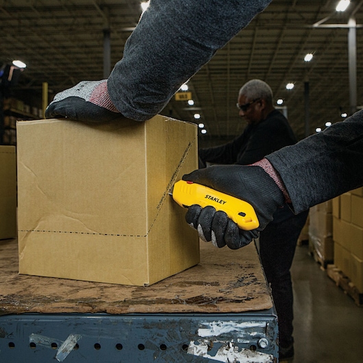 Squeeze Safety Knife being used for cutting cardboard box.